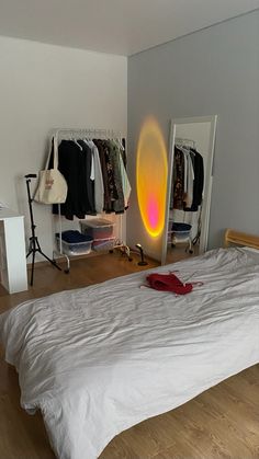 a white bed sitting in a bedroom next to a mirror