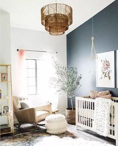 a baby's room with blue walls and white furniture