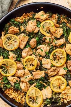 a skillet filled with chicken, lemons and spinach on top of rice