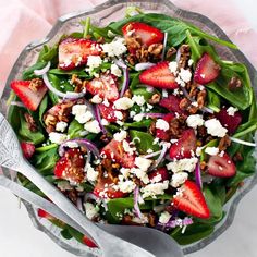 a salad with spinach, strawberries and feta cheese