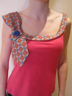 a woman wearing a pink dress with an orange and blue neck tie on her chest