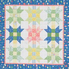 a blue quilt with multicolored stars on the top and bottom, along with an orange border