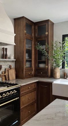 a kitchen with marble counter tops and wooden cabinets, along with a white stove top oven