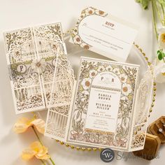 the wedding stationery is laid out on a plate with flowers in front of it