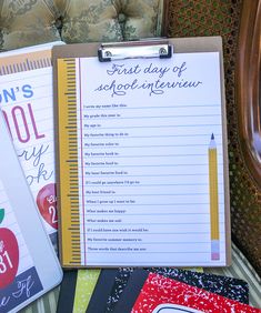 there is a clipboard with an apple on it next to notebooks and books