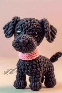 a crocheted black dog with a pink collar