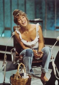 a woman sitting in a chair next to a basket