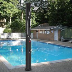 an empty swimming pool with a basketball hoop in the middle and a house behind it