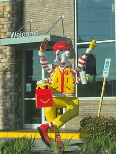 there is a statue of a man in a mcdonalds uniform holding up his arms