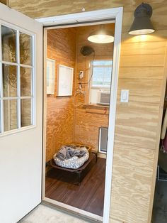 an open door leading into a room with a dog bed on the floor in it