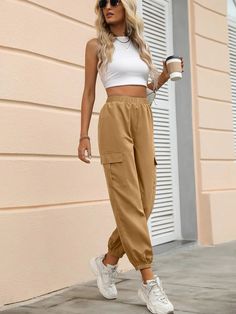 Introducing our Elastic Waist Joggers, the epitome of comfort and style. These joggers effortlessly combine practicality with a touch of sophistication, making them a must-have addition to your wardrobe. Crafted with meticulous attention to detail, these joggers feature a high waist design that flatters your silhouette and accentuates your natural shape. The cropped length adds a modern twist, allowing for easy movement and showcasing your favorite footwear. Specifications: Details: Button, Pock Trendy Joggers With Elastic Side Panels For Spring, Trendy Spring Joggers With Elastic Side Panels, Trendy Solid Joggers With Tapered Leg, Fall Athleisure Cargo Style Pants, Trendy Spring Joggers With Cargo Pockets, Spring Cargo Style Relaxed Fit Joggers, Trendy Joggers With Pockets For Leisure, Trendy Leisure Joggers With Pockets, Casual Fall Joggers With Cuffed Ankles