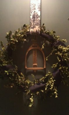 a wreath is hanging on the wall next to a plaque with an arrow in it