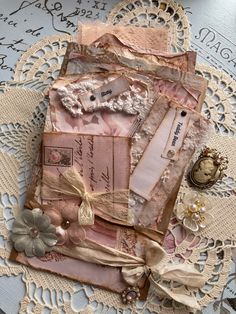 an altered piece of fabric and lace on a doily with flowers, ribbons and buttons