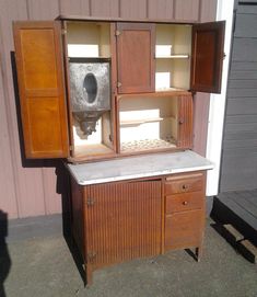 an old fashioned wooden cabinet with a sink in the center and cupboards on both sides