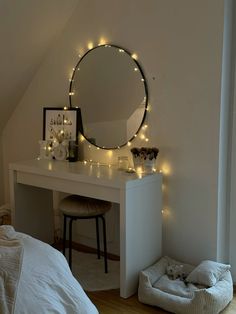 a bedroom with a mirror, stool and lights on the wall above it's bed