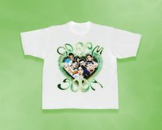 a white t - shirt with an image of people in the center and green lettering on it