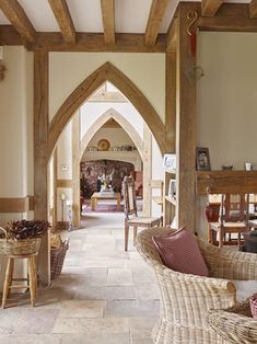 the inside of a house with wooden beams and wicker furniture on either side of the room