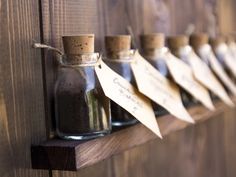 a row of bottles filled with sand sitting on top of a wooden shelf