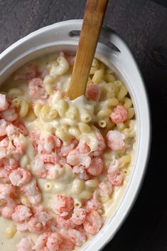 a bowl filled with macaroni and cheese next to a wooden spoon