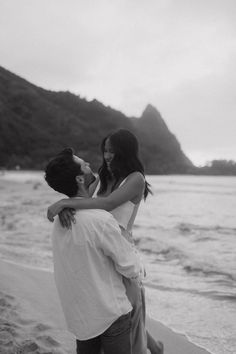 a man holding a woman on the beach