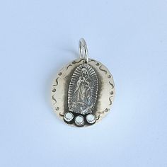 Please allow 10-14 weeks for this item to be custom made Sterling silver hammered disc pendant with Guadalupe and Mother of Pearl Designed by Richard Schmidt Silver Our Lady Of Guadalupe Necklace, Silver Our Lady Of Guadalupe Pendant Jewelry, Silver Hammered Amulet Jewelry, Silver Hammered Oval Pendant Jewelry, Richard Schmidt, Mother Of Pearl Pendant, Pearl Design, Disc Pendant, Hammered Silver