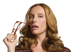 a woman with glasses on her face is holding something in front of her eyeglasses