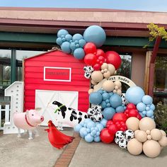 there is a large number of balloons in the shape of animals and cows on display