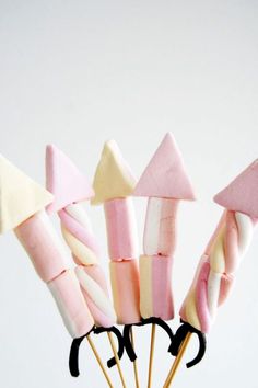 several marshmallows are arranged on sticks in a vase