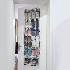 an over the door shoe rack holds many pairs of shoes and is hanging on a wall