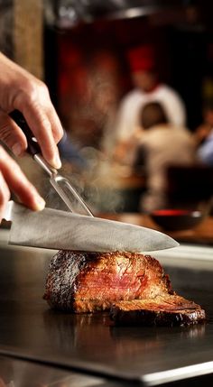 a person cutting meat with a large knife