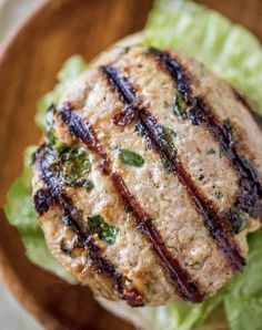 a close up of a burger on a plate with lettuce