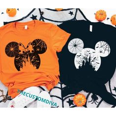 two mickey mouse t - shirts sitting on top of an orange chair next to pumpkins