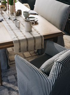 a dining room table with two chairs and a coffee cup on it's side