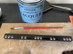 some tools are sitting on a table next to a paint can and brush, ruler