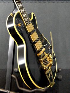 a black and gold guitar is on display