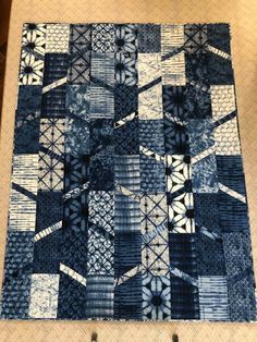 a blue and white patchwork quilt sitting on top of a table