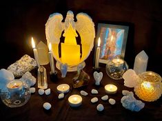 a table topped with candles and angel figurines next to an advertisement for sale