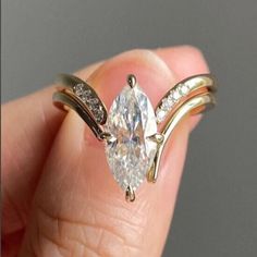 a person holding a ring with a large diamond in it's middle and two smaller diamonds on each side