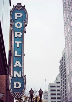 a sign that is on the side of a building in front of some tall buildings