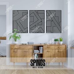 two black and white paintings hanging on the wall above a wooden dresser in a bedroom