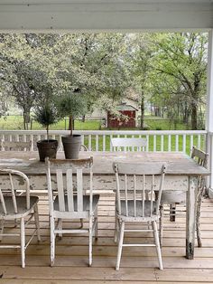 an outdoor table and chairs on a porch