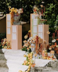 there are many items on the table with flowers and fruit in front of each other