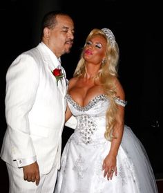 a man in a white suit kissing a woman in a wedding dress on the dance floor