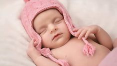 a newborn baby wearing a pink knitted hat