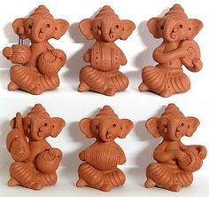 there are many small clay elephants that have been made to look like they are holding something in their hands