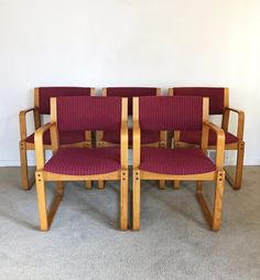 four chairs sitting side by side in a room with carpeted floor and white walls