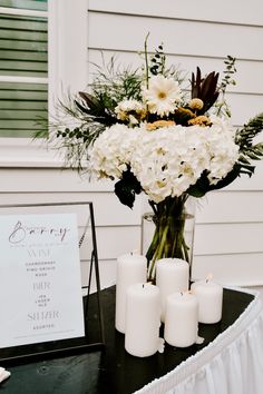 white flowers and candles are on a table