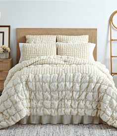 a bed with white comforter and pillows in a room