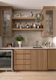 a kitchen that has wooden cabinets and glass shelves on the wall, along with an oven