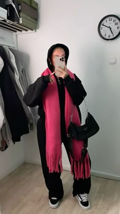 a woman taking a selfie in front of a mirror wearing a pink and black outfit